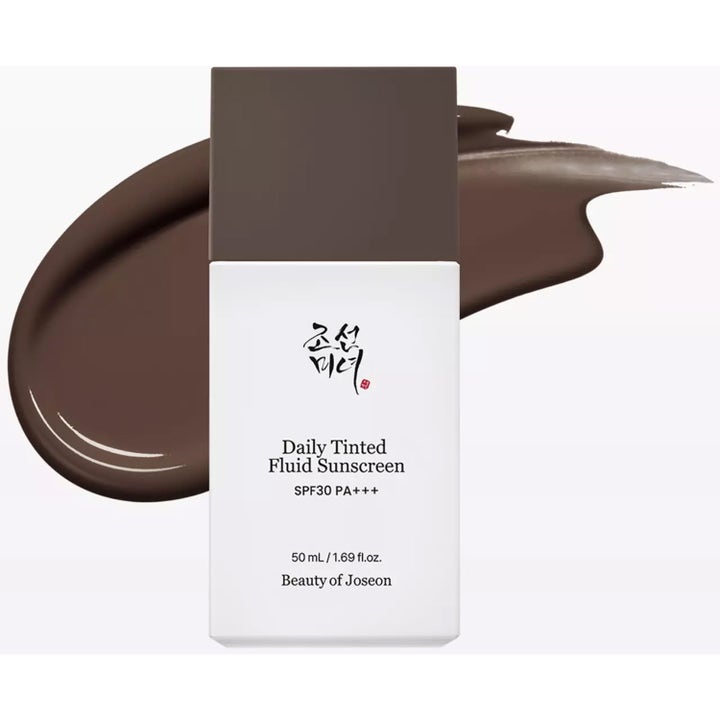 Beauty of Joseon Daily Tinted Fluid Sunscreen 50 ml sävyttävä aurinkovoide valkoisessa pullossa ja ruskea voidenäyte.