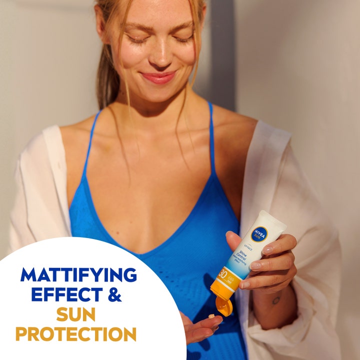 NIVEA Sun UV Face Shine Control Cream 50 ml mattaava aurinkovoide kasvoille nainen ottaa voidetta tuubista