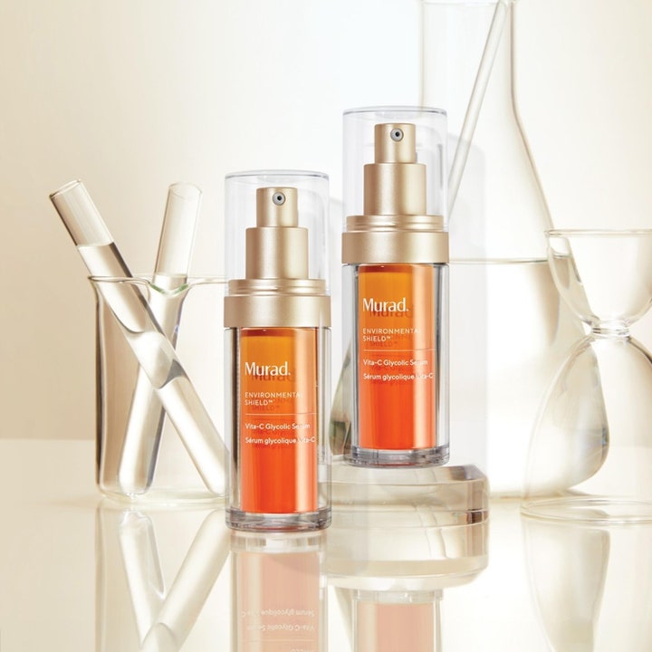 Murad Vita-C Glycolic Serum 30 ml kirkastava seerumi oransseissa pulloissa laboratoriolasien ja koeputkien kanssa