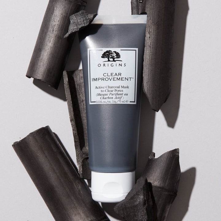 Origins Clear Improvement 75 ml syväpuhdistava hiilinaamio puhdistaa ihohuokosia harmaassa tuubissa hiilenpalojen keskellä