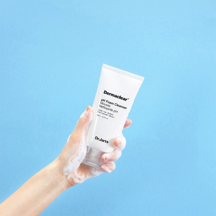 Dr.Jart+ Dermaclear pH Foam Cleanser 120 ml puhdistusvaahto valkoisessa tuubissa vaahtoisessa kädessä sinisellä taustalla
