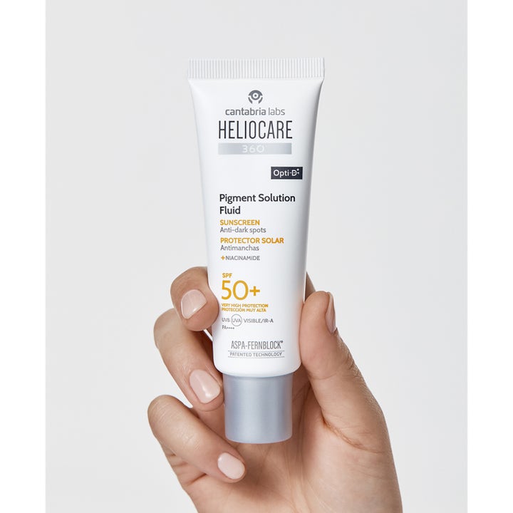 Heliocare Pigment Solution Fluid SPF 50+ 50 ml pigmenttiläiskiä ehkäisevä aurinkosuoja kädessä pidetyssä valkoisessa tuubissa.