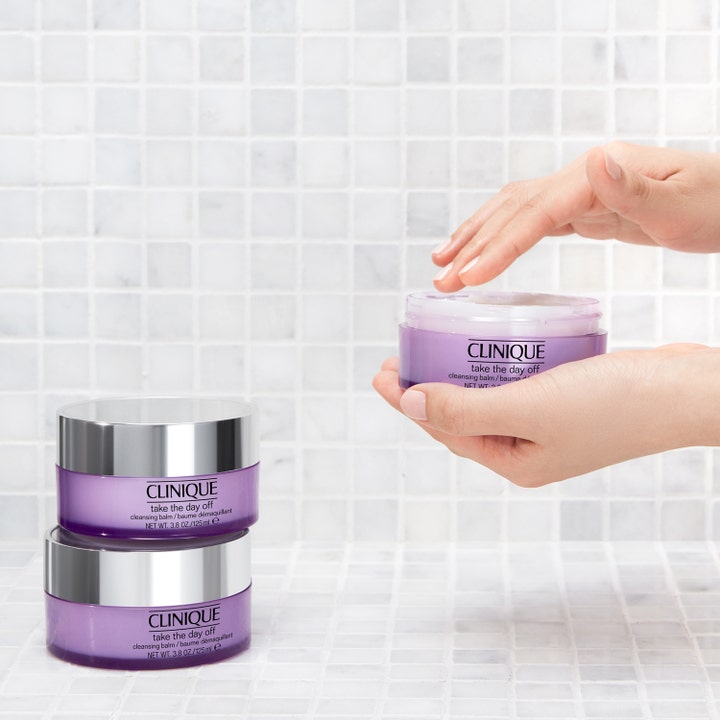 Clinique Take The Day Off Cleansing Balm 125 ml meikinpoistoaine avatussa liilassa purkissa ja pinossa.