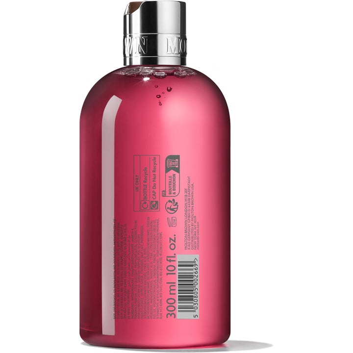Molton Brown Fiery Pink Pepper 300 ml suihkugeeli läpinäkyvässä pullossa, jossa näkyy ainesosat ja kierrätysmerkinnät.