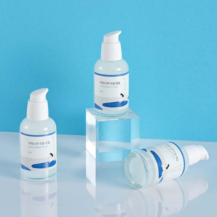 Round Lab Birch Juice Moisturizing Serum 50 ml kosteuttava seerumi kolme pumppupulloa kirkkaalla jalustalla.