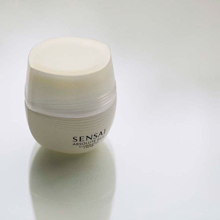 Sensai Absolute Silk Illuminative Cream 40 ml heleyttävä kasvovoide valkoisessa pyöreässä ja teksturoidussa purkissa