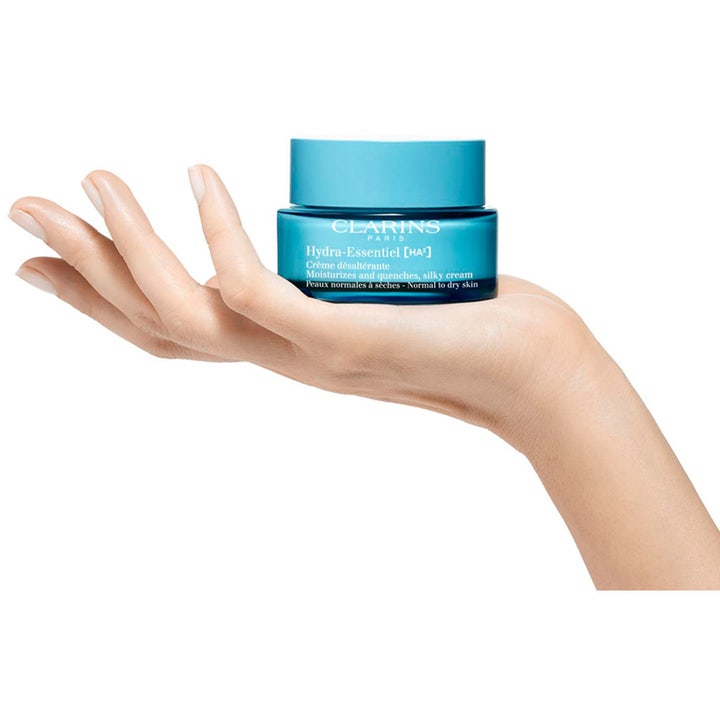 Clarins Hydra-Essentiel Silky Cream 50 ml kosteuttava päivävoide sinisessä lasipurkissa kämmenellä.
