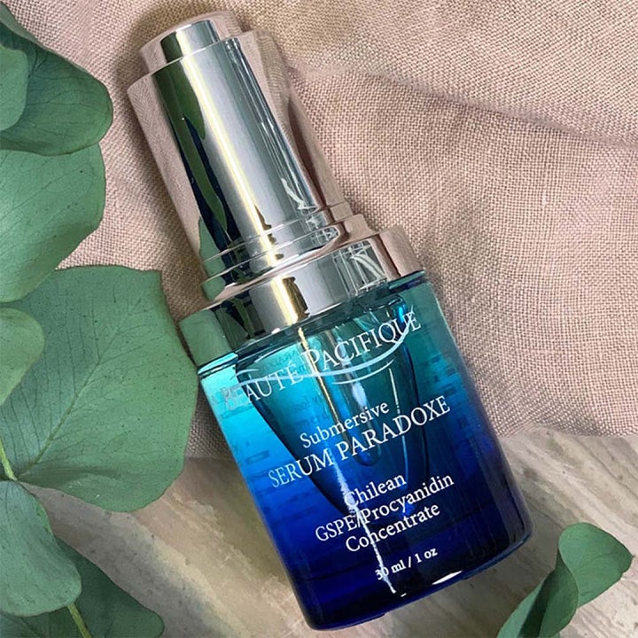 Beauté Pacifique Submersive Serum Paradoxe 30 ml anti-age seerumi sinisessä lasipullossa vihreiden lehtien kera.