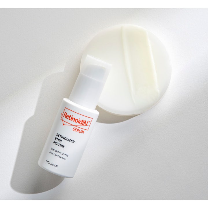 It'S SKIN Retinoidin Serum 30 ml uudistava kasvoseerumi valkoisessa pumppupullossa ja kermainen koostumusnäyte.
