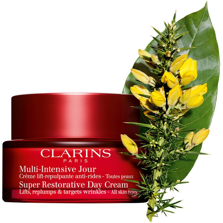 Clarins Super Restorative Day Cream 50 ml kiinteyttävä päivävoide punaisessa purkissa keltaisten kukkien ja lehden kera.