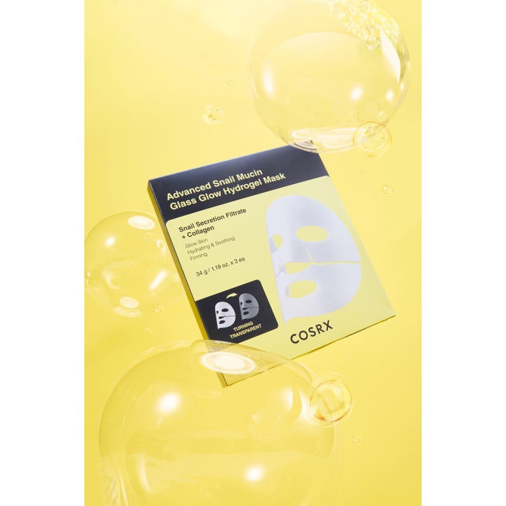 COSRX Advanced Snail Mucin Power Activating Hydrogel Mask 3 kpl kosteuttava kangasmaski keltaisella taustalla kuplilla.