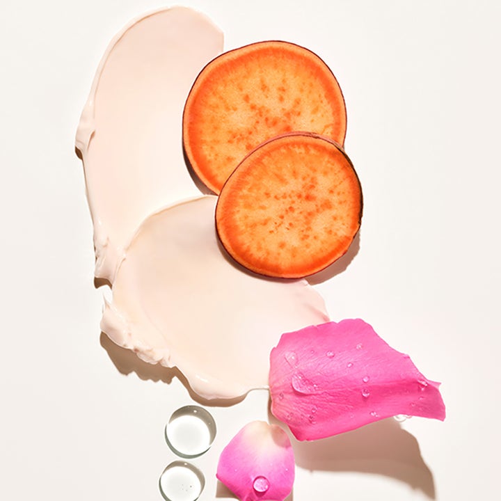 Sol de Janeiro Rosa Charmosa Dewy Cream 75 ml kosteuttava vartalovoide, vaaleanpunainen voidekoostumus ja ruusun terälehtiä.