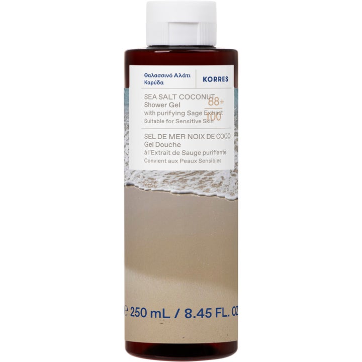 Korres Sea Salt Coconut 250 ml puhdistava suihkugeeli ruskeassa pullossa, jossa on rantamaisema.