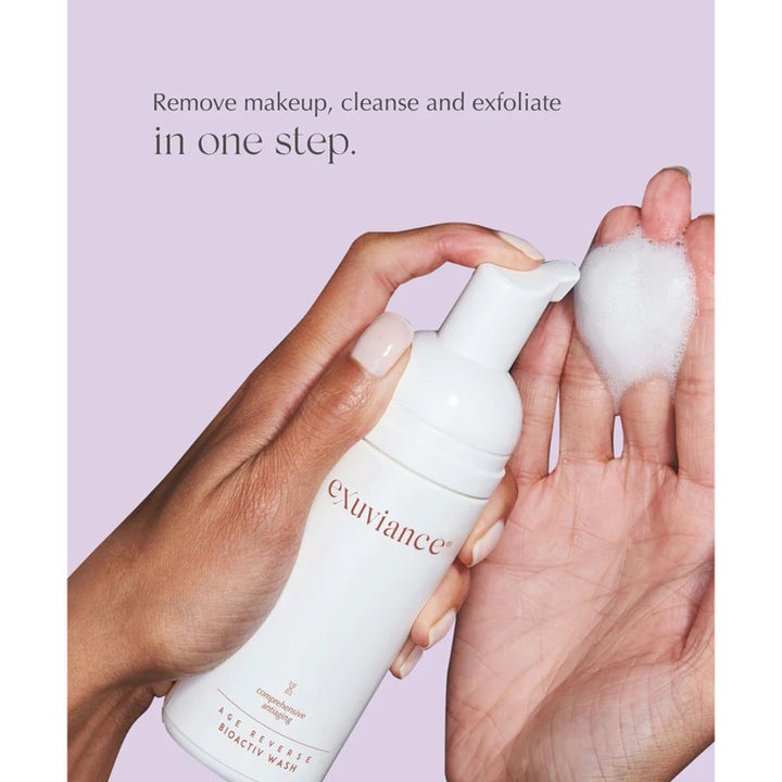 Exuviance Age Reverse BioActiv Wash 125 ml kuoriva puhdistusvaahto valkoisessa pumppupullossa vaahtona kämmenellä.