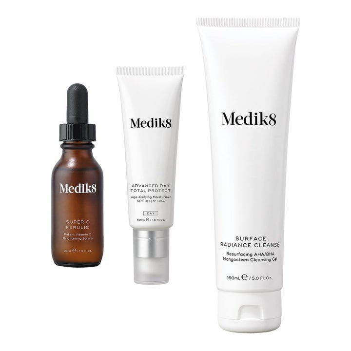 Medik8 kirkastava ihonhoitosetti sisältää puhdistusgeelin seerumin ja SPF 30 voiteen valkoisissa tuubeissa ja lasipullossa.