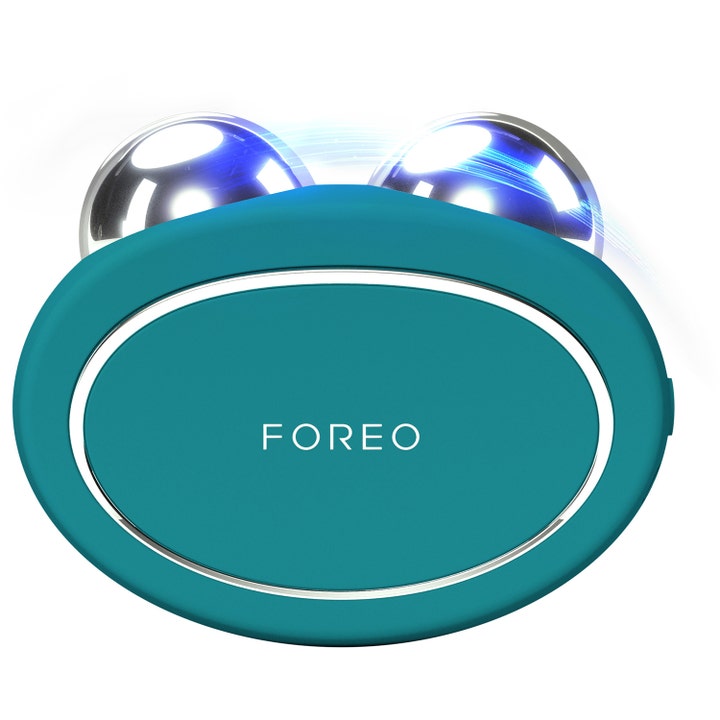 Foreo Bear kiinteyttävä mikrovirtalaite kasvoille turkoosi ovaalinmuotoinen laite kahdella hopeisella pallolla.