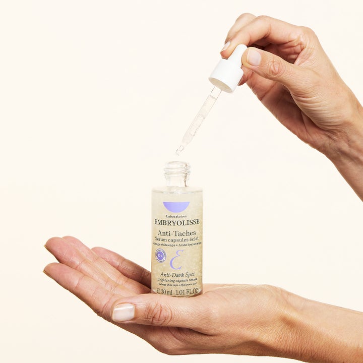 Embryolisse Dark Spot Serum 30 ml kirkastava seerumi ja pipetti kämmenellä annosteltuna.