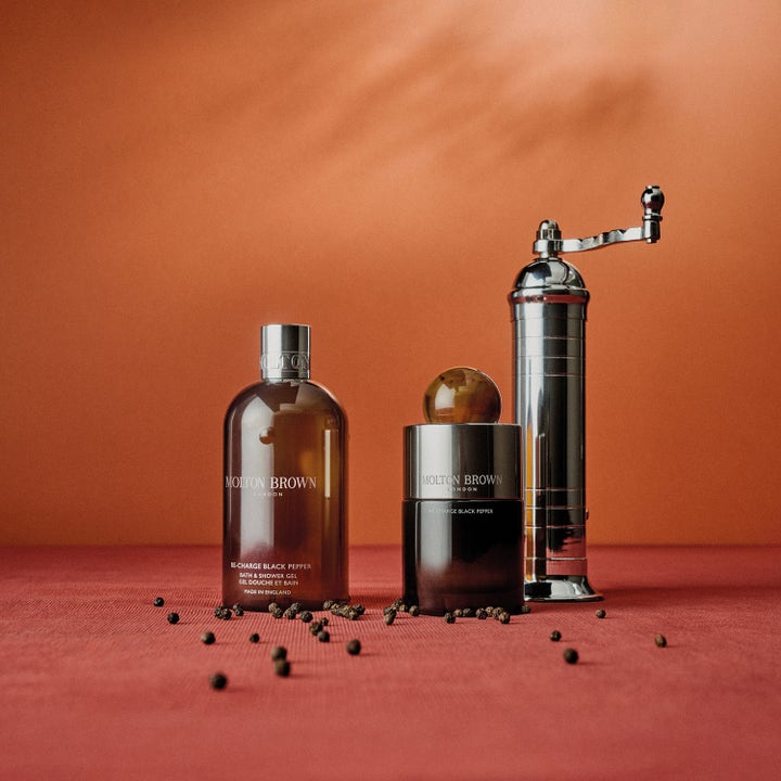 Molton Brown Black Peppercorn 300 ml puhdistava suihkugeeli tyylikkäässä asetelmassa pippurimyllyn seurana