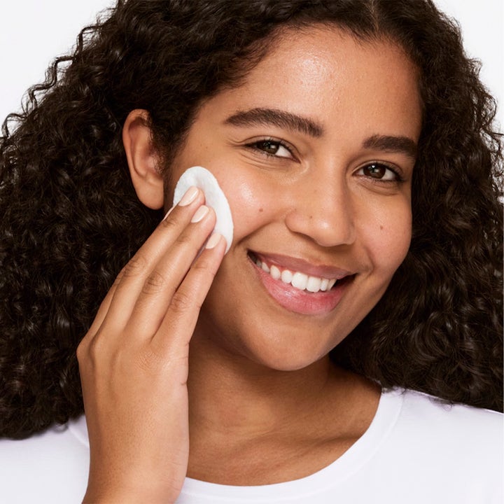 Clinique Clarifying Lotion Twice a Day Exfoliator 3 487 ml kirkastava kasvovesi nainen levittää vanulapulla kasvoilleen