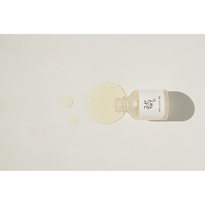 Beauty of Joseon Glow Serum heleyttävä seerumi makuullaan olevasta pullosta valuva kellertävä koostumus