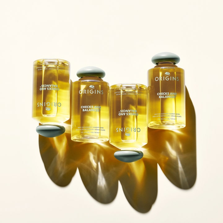 Origins Checks & Balances Milky Oil Cleanser 150 ml puhdistusöljy neljässä kultaisessa pullossa vihreillä korkeilla.
