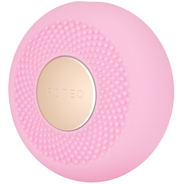 FOREO UFO mini 2 Pearl Pink ihoa kirkastava kasvolaite on pyöreä vaaleanpunainen silikonilaite kultaisella logolla.