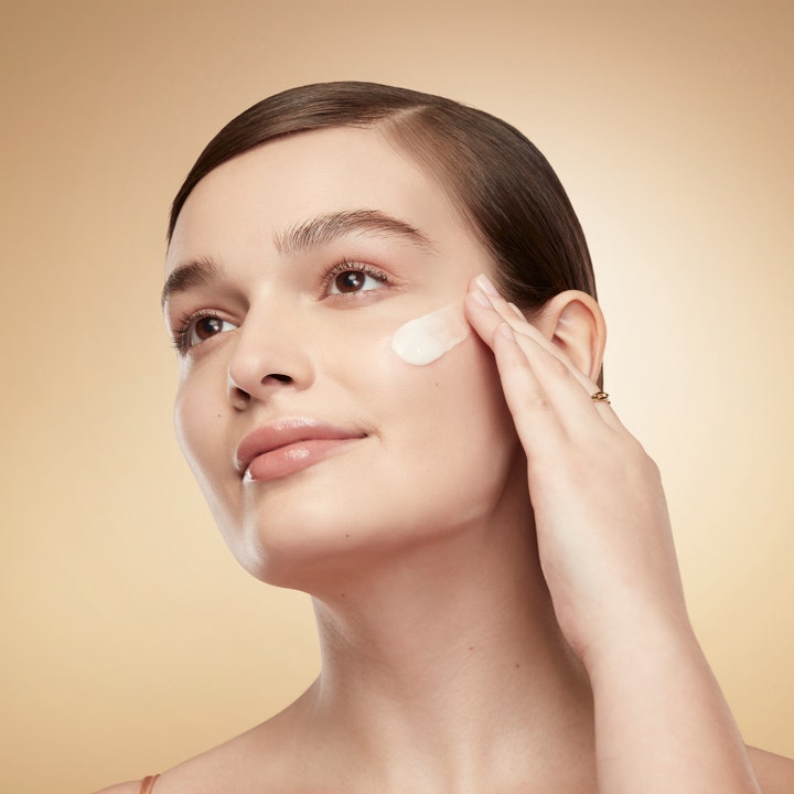 Estée Lauder Revitalizing Supreme+ Youth Power Creme 30 ml kiinteyttävä päivävoide nainen levittää voidetta poskelle.