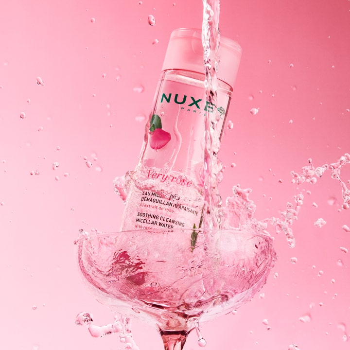 Nuxe Very Rose Micellar Water 200 ml rauhoittava misellivesi vaaleanpunaisessa pullossa veden roiskuessa.