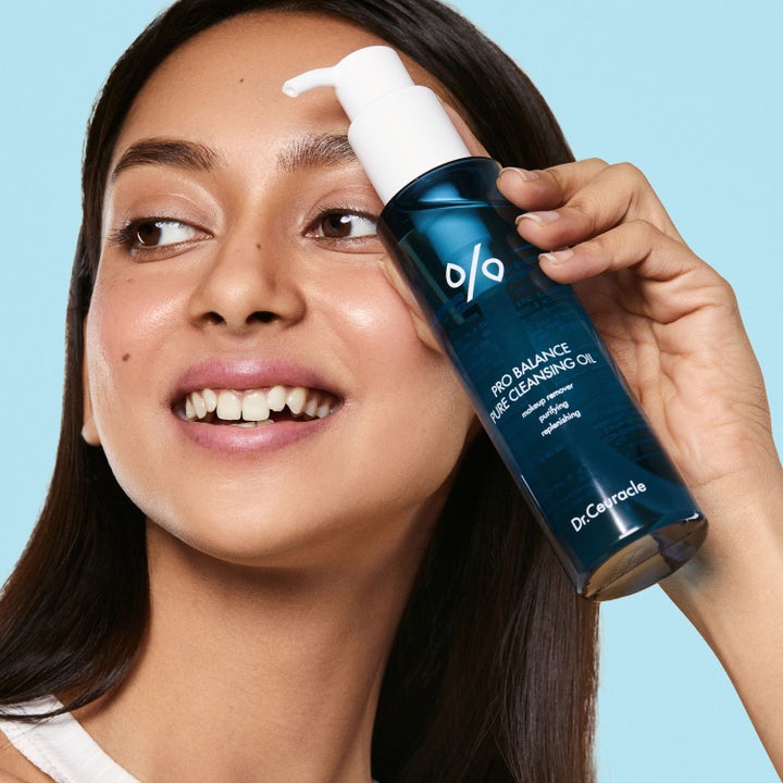 Dr. Ceuracle Pro Balance Pure Cleansing Oil 155 ml puhdistava meikinpoistoöljy sinisessä pullossa naisen pitelemänä.