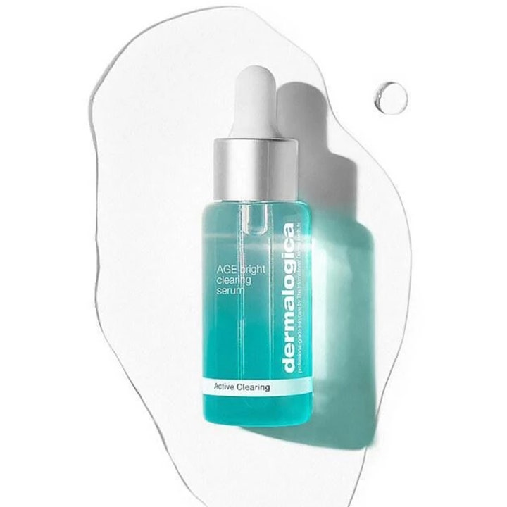 Dermalogica AGE Bright Clearing Serum 30 ml kirkastava seerumi turkoosissa pipettipullossa kirkkaan nesteen päällä.