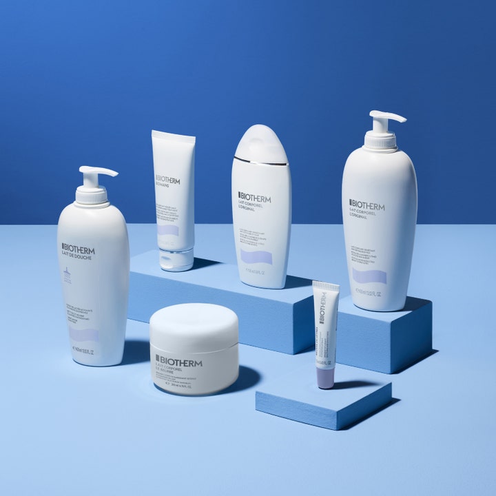Biotherm Lait Corporel Moisturizing Shower Milk 400 ml kosteuttava suihkuvoide osana tuotesarjaa sinisillä korokkeilla.