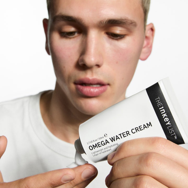 The INKEY List Omega Water Cream 50 ml kosteuttava kasvovoide mies puristaa kevyttä voidetta tuubista sormelle.