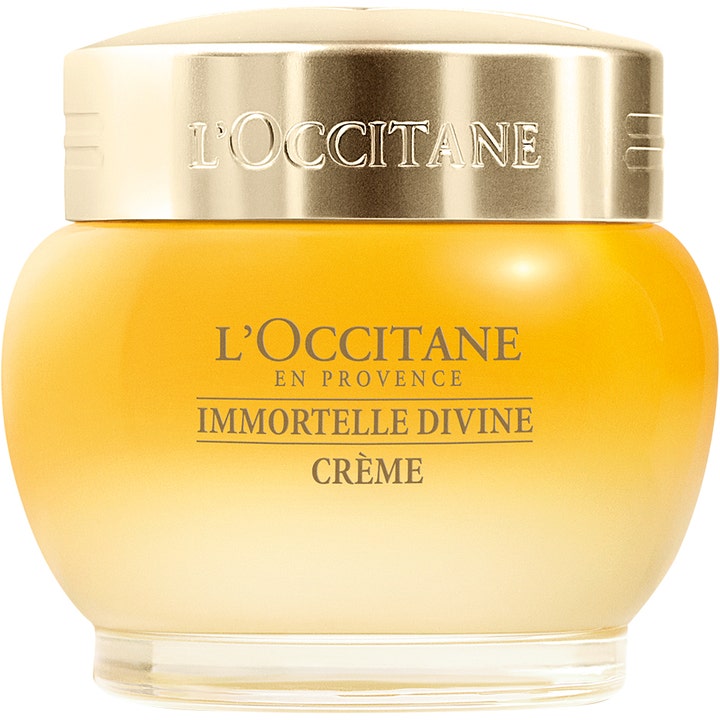 L'Occitane Immortelle Divine Crème silottava kasvovoide pyöreässä keltaisessa lasipurkissa kultaisella korkilla.