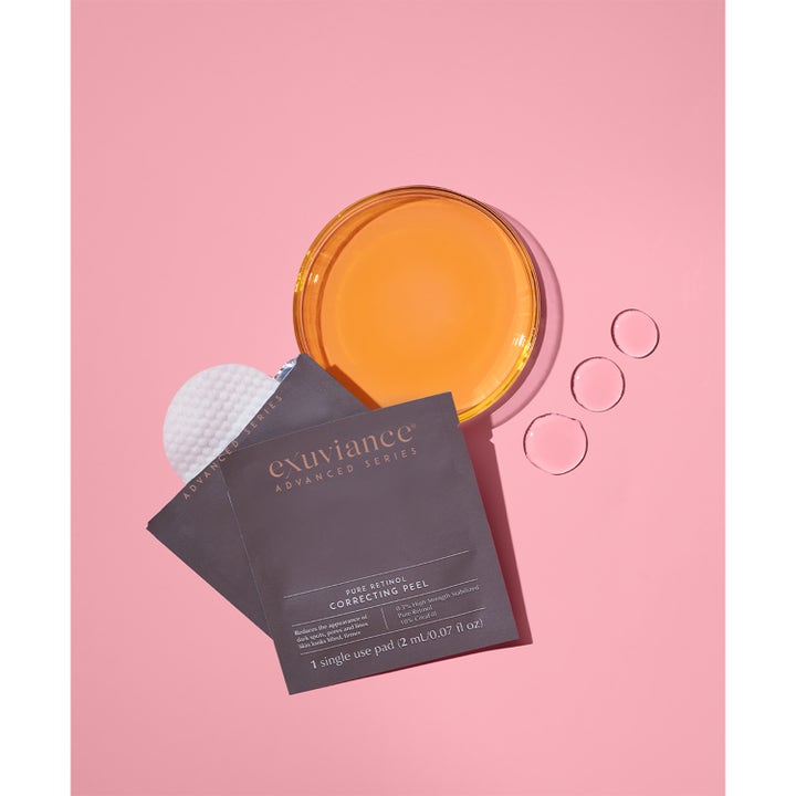 Exuviance Pure Retinol Correcting Peel 6 kpl kirkastava kuorinta harmaa pussi ja valkoinen lappu pinkillä.