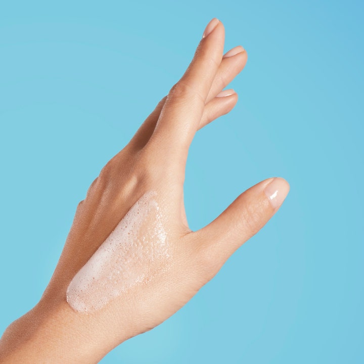 Biotherm Oil Therapy Baume Corps 200 ml kosteuttava suihkugeeli ja pehmeää valkoista vaahtoa kämmenselällä