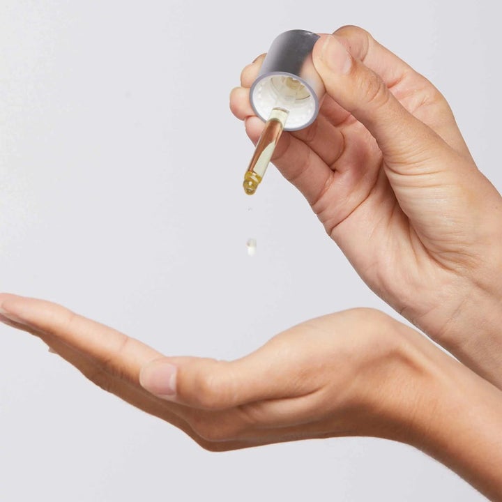 Dermalogica Retinol Clearing Oil Duo kirkastava kasvoöljy pipetti annostelee keltaista öljyä kämmenelle