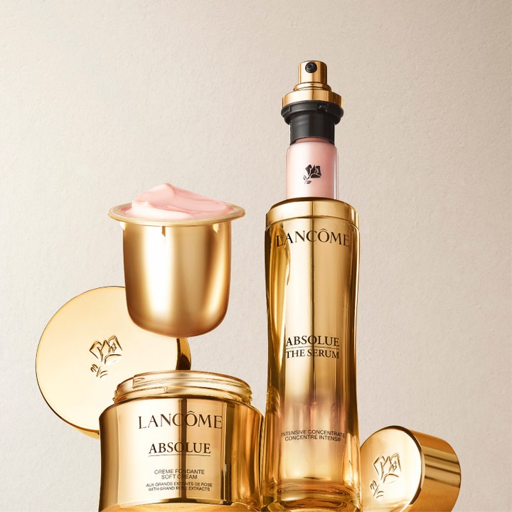 Lancôme Absolue The Serum 30 ml heleyttävä seerumi kultaisessa pullossa ja ylellinen vaaleanpunainen kasvovoide.