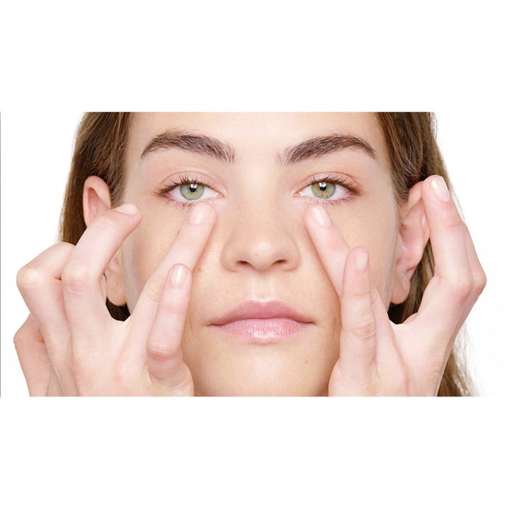 Clinique Total Eye Care 30 ml anti-age-silmänympärysvoide levitettynä sormin silmien alle häivyttämään juonteita.