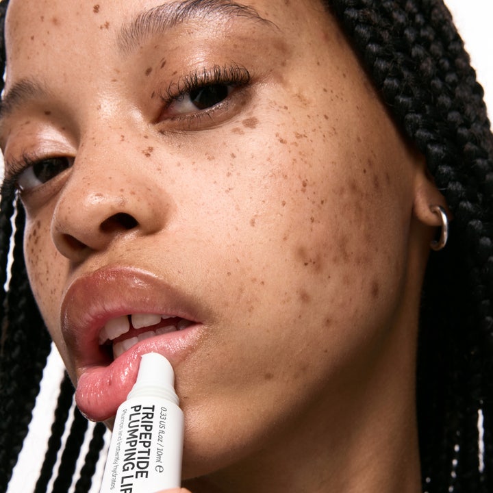 The INKEY List Tripeptide Plumping Lip Balm 10 ml kosteuttava ja täyteläisyyttä antava huulivoide mallin huulilla.