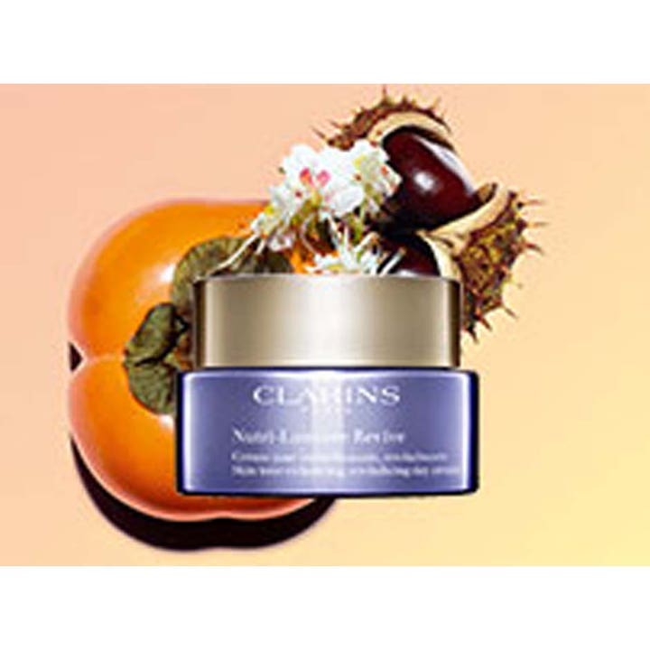 Clarins Nutri-Lumière Revive 50 ml kirkastava päivävoide purppurassa lasipurkissa kaki-hedelmän ja kastanjan kanssa.