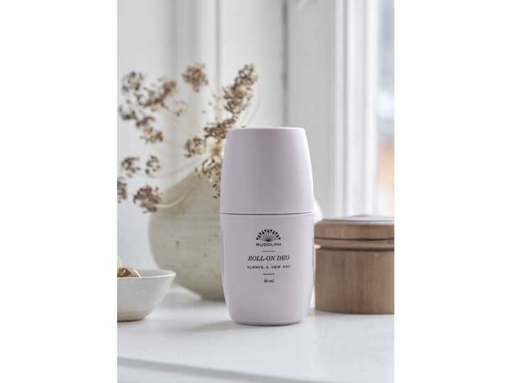 Rudolph Care Acai Keep On Rolling Deodorant 50 ml raikastava deodorantti vaaleanpunaisessa pakkauksessa sisustuselementtien kera