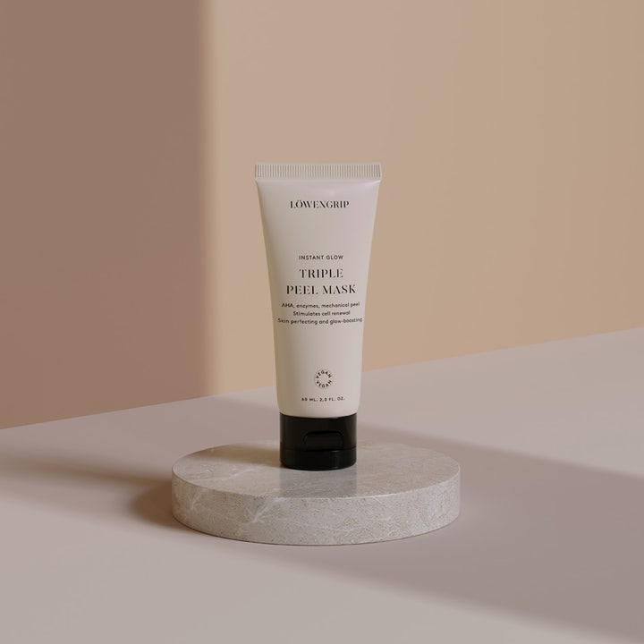 Löwengrip Instant Glow Triple Peel Mask 60 ml heleyttävä AHA-kasvonaamio vaaleassa tuubissa marmorialustalla.