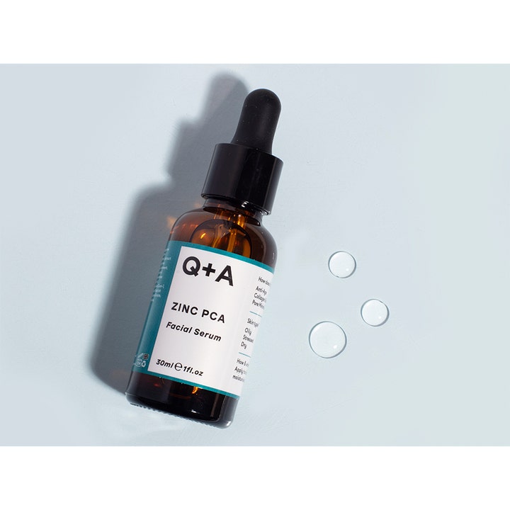 Q+A Zinc PCA Facial Serum 30 ml tasapainottava kasvoseerumi ruskeassa lasipullossa ja kirkkaita pisaroita
