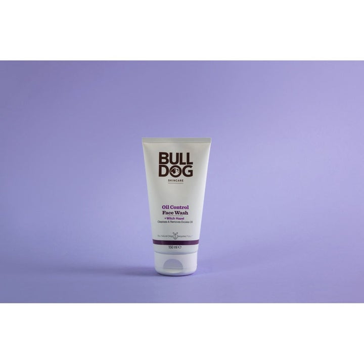 Bulldog Oil Control Face Wash 150 ml puhdistava kasvopesu taikapähkinällä valkoisessa tuubissa liilalla taustalla.