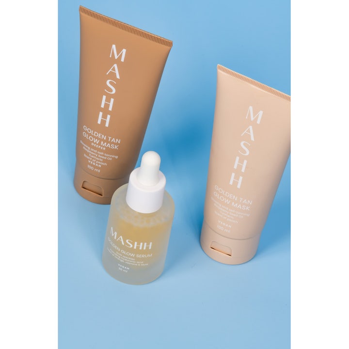 MASHH Golden Glow Serum 30 ml kirkastava seerumi huurteisessa lasipullossa kahden naamion edessä sinisellä taustalla.
