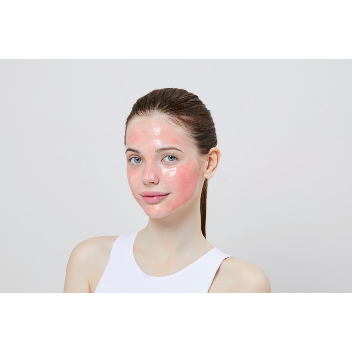 COSRX The AHA BHA PHA LHA 35 Peel 30 ml kirkastava kuorinta levitettynä vaaleanpunaisena maskina naisen kasvoille.