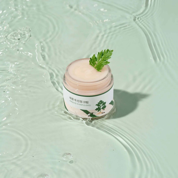 Round Lab Mugwort Calming Cream 80 ml rauhoittava kasvovoide avatussa purkissa vihreän lehden kanssa vedessä.