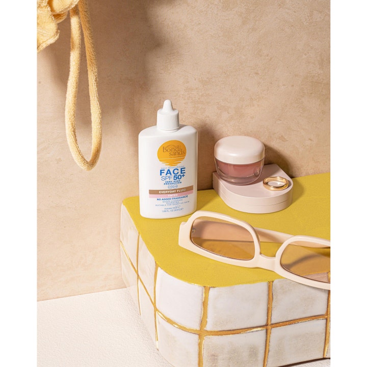 Bondi Sands SPF50+ Everyday Tinted Face Fluid 50 ml kosteuttava sävytetty aurinkovoide valkoisessa pullossa aurinkolasien kera