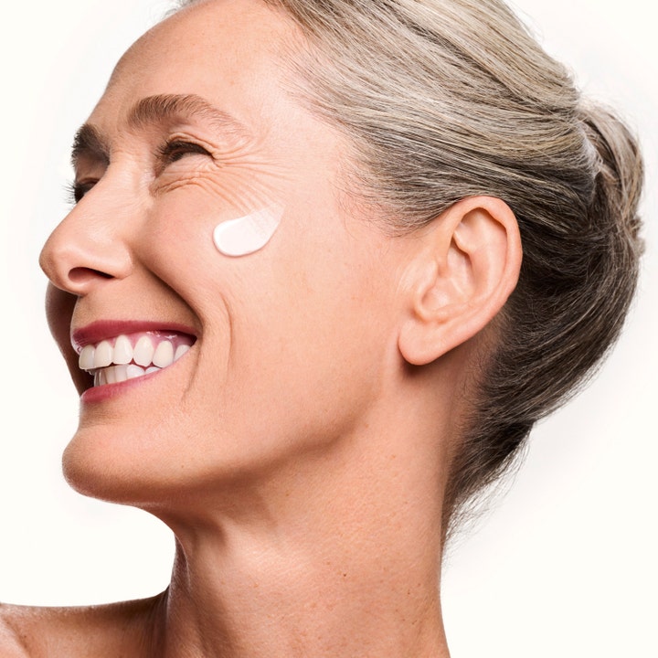 Shiseido Vital Perfection Concentrated Supreme Cream 50 ml kasvovoide hymyilevän naisen poskella.