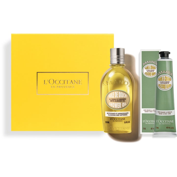 L'Occitane Amande 250ml ja 75ml pehmentävä ihonhoitosetti keltaisessa rasiassa, jossa on kirkas pullo ja vihreä tuubi.